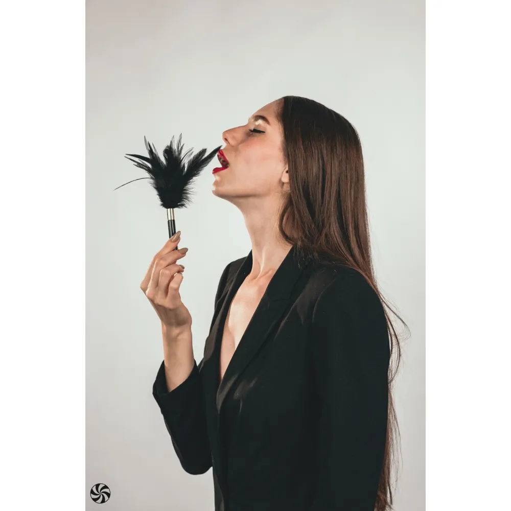 Peruška crna - Burlesque Plume - prikaz žene koja drži perušku u ruci i nježno njome prelazi preko usnica